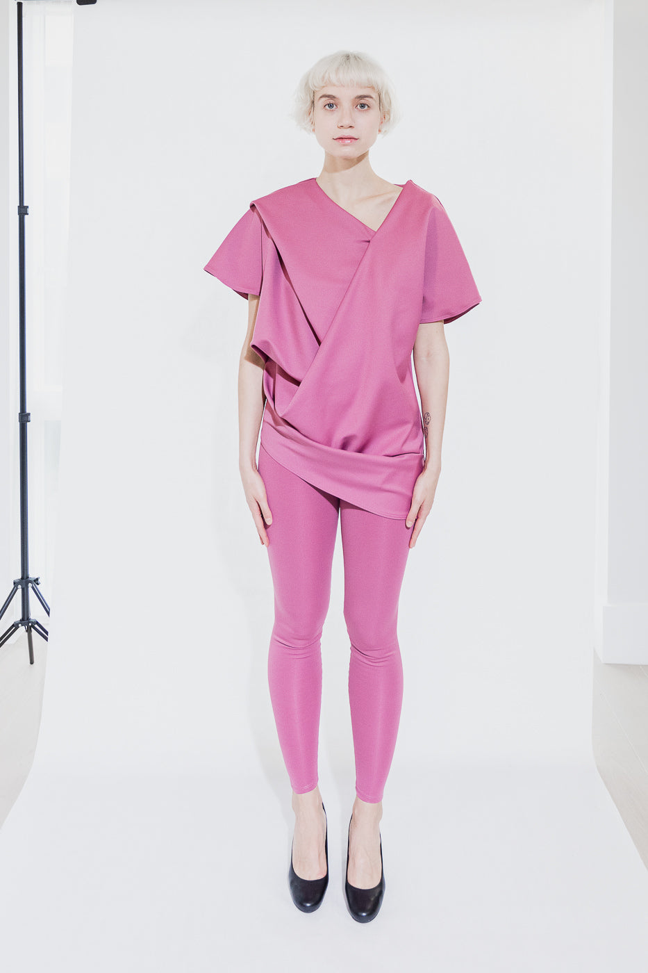 Asymmetrical pink top and leggings outfit (person)