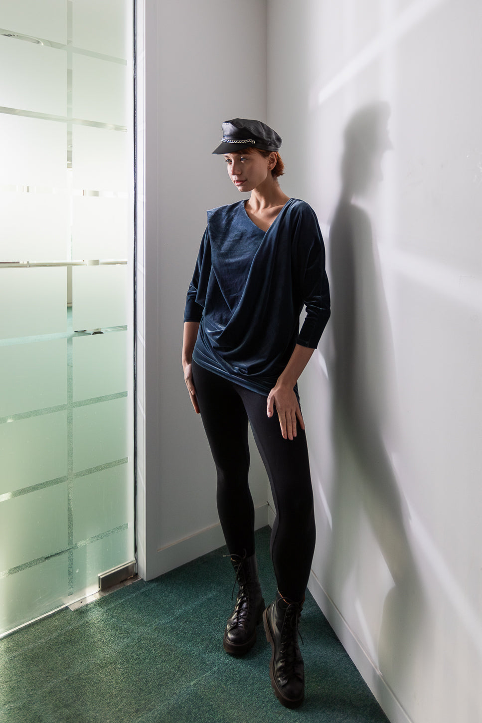 Navy blue draped top with black leggings and boots (person)