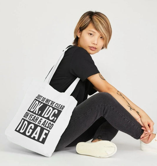 White tote bag with black text (person)