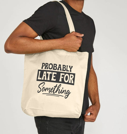 White tote bag with "PROBABLY LATE FOR SOMETHING" text (person)