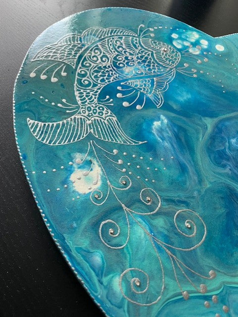 Painted ceramic fish with intricate white designs