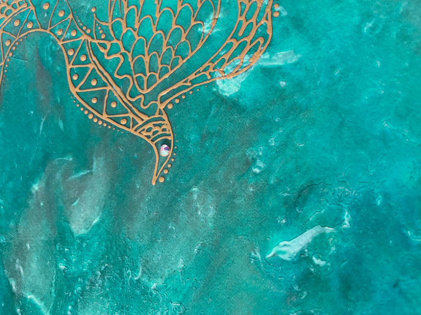 Intricate gold bird design on teal background