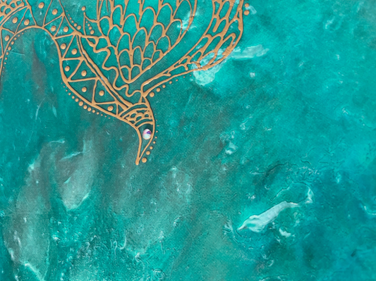 Intricate gold bird design on teal background