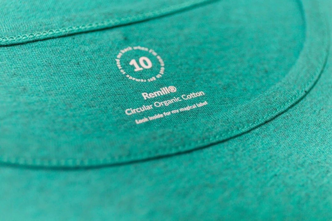 Teal t-shirt with "Remill®" and "Circular Organic Cotton" text