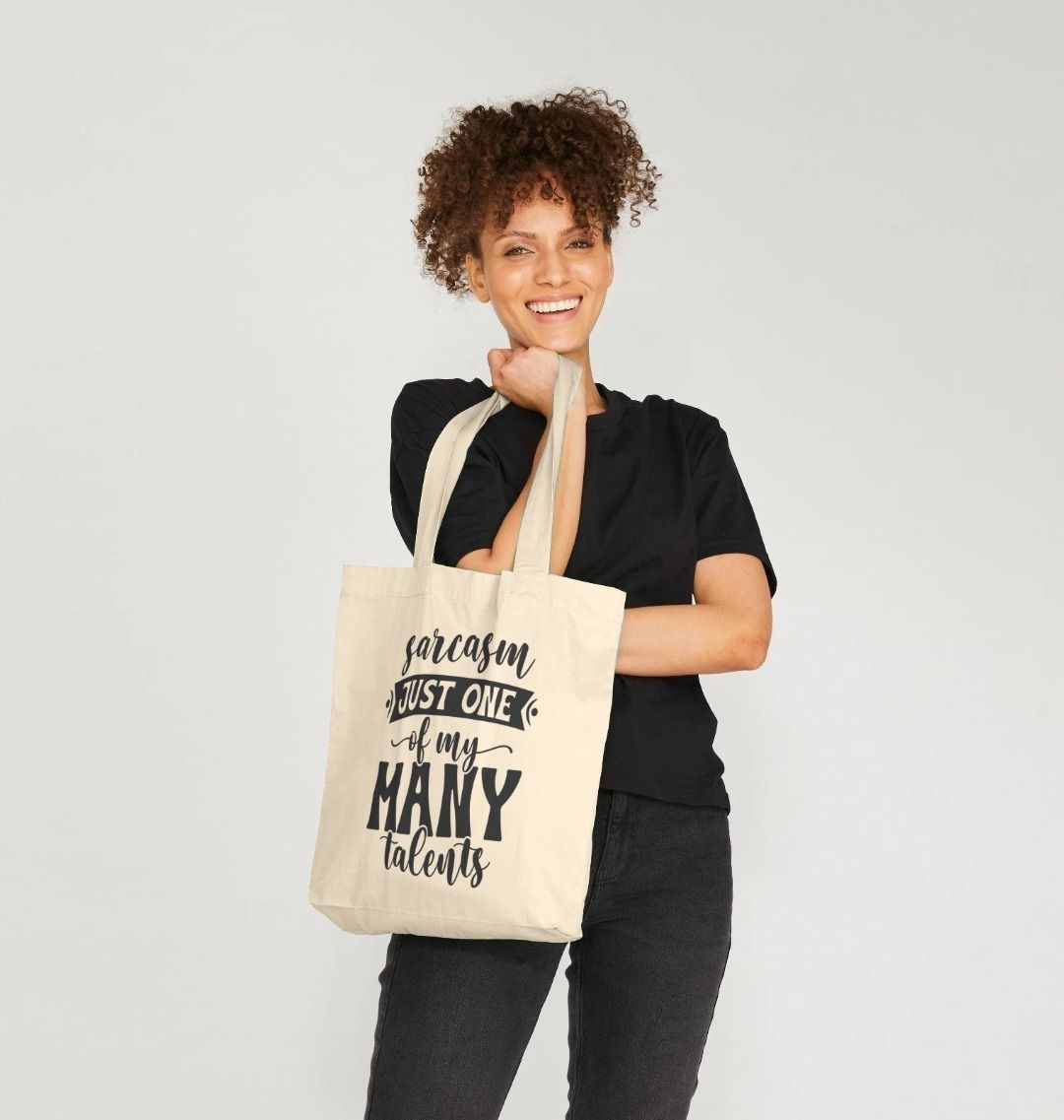 Natural canvas tote bag with "sarcasm just one of my many talents" text (person)