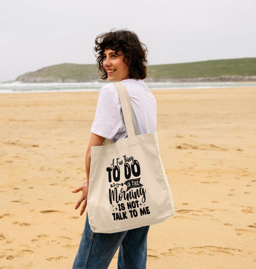 White tote bag with black text (person)