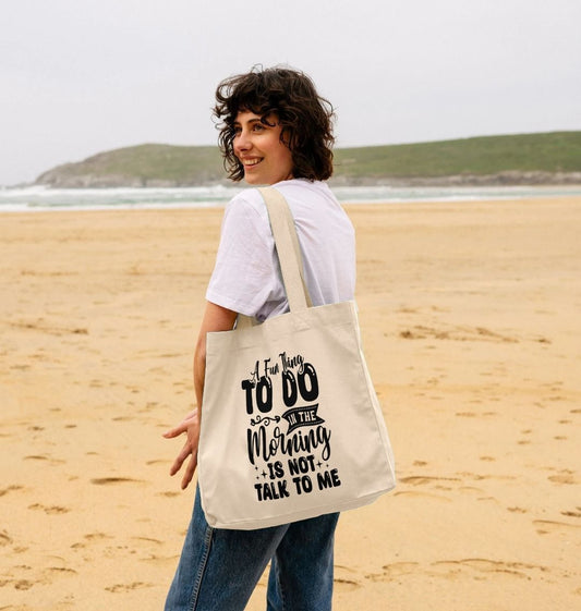 White tote bag with black text (person)