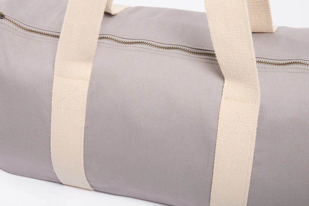 Gray canvas duffel bag with beige handles