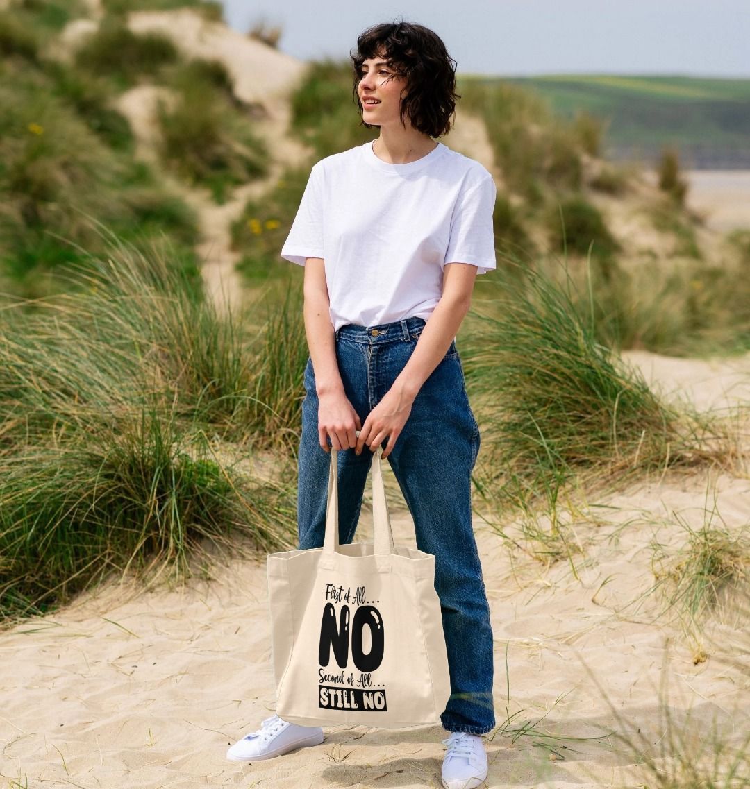Natural canvas tote bag with "First of All... NO Second of All... STILL NO" text (person)